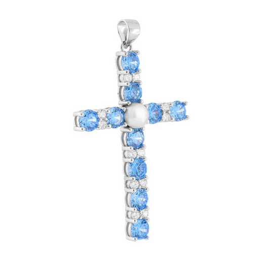 Ciondolo a forma di croce in oro bianco, con gemme blu e bianche e una perla al centro.