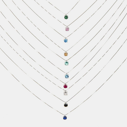 Dieci collane d'argento con pendenti a punto luce di diversi colori, tra cui verde, rosa, blu, giallo e nero.