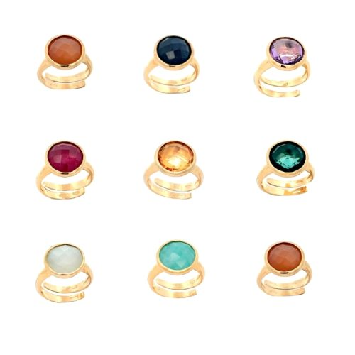 Anelli in oro con pietre ovali di diversi colori: arancione, blu, viola, rosso, giallo, verde, azzurro e bianco.