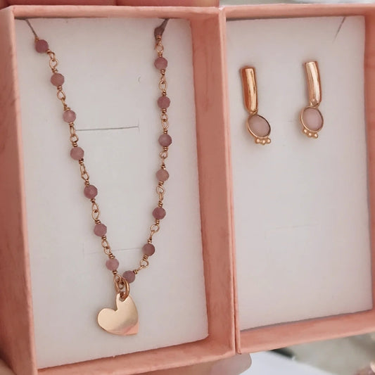 Collana e orecchini in oro rosa in una scatola regalo.